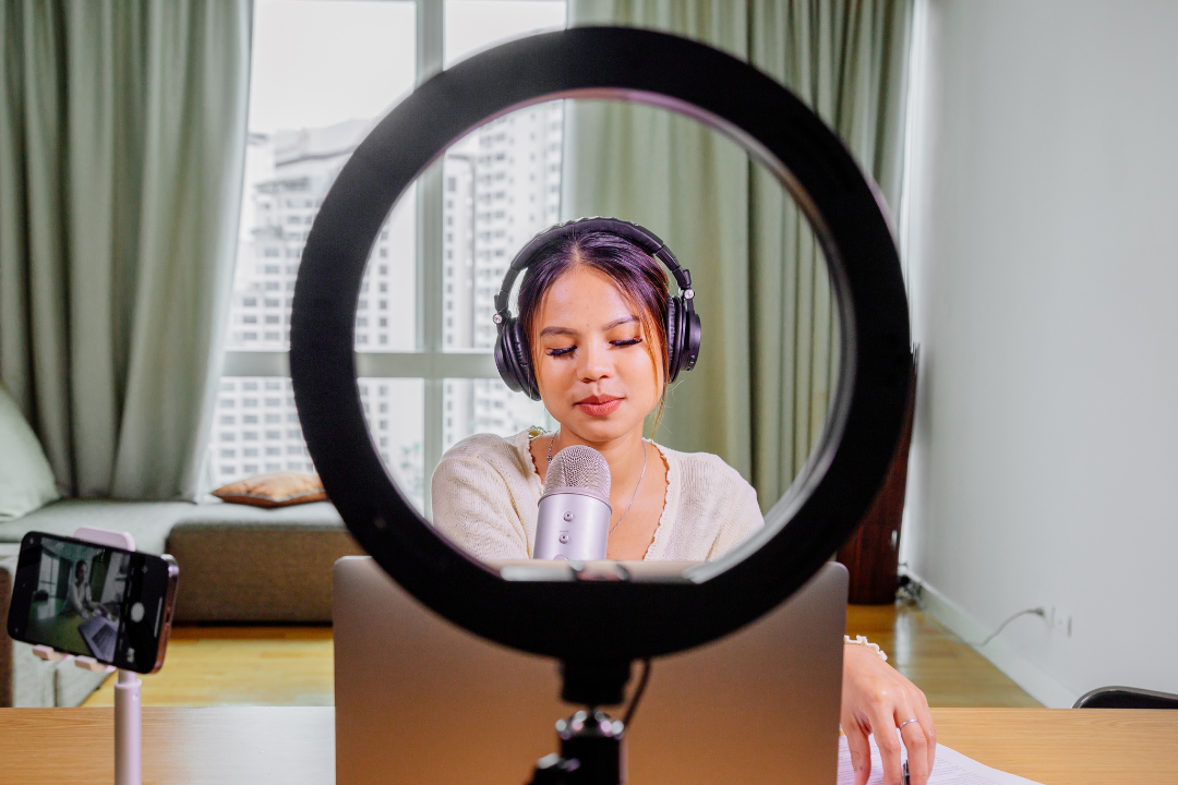 A creator filming short-form video content using a smartphone and ring light.